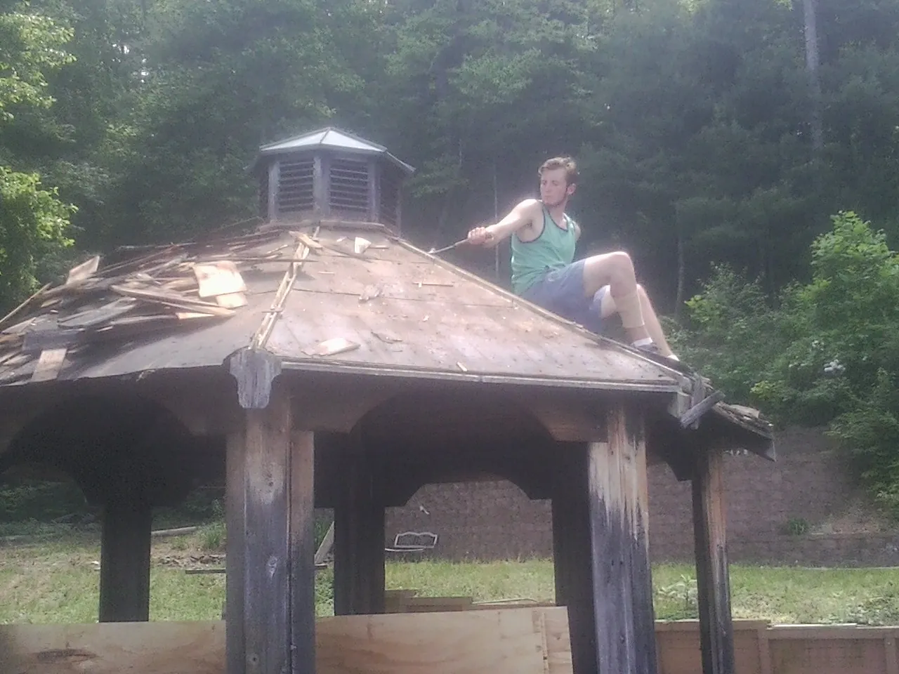 Tearing the old roof off a wooden gazebo before new shakes in Good Thunder
