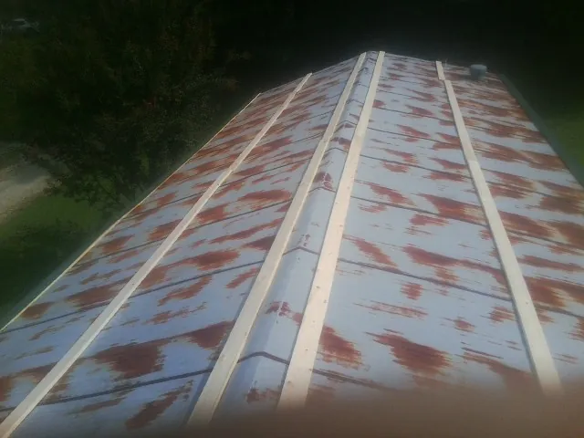 Rusted metal roof panels with new wood purlins before replacement — Storm Damage Roof Repair in Good Thunder by Roofing Brothers