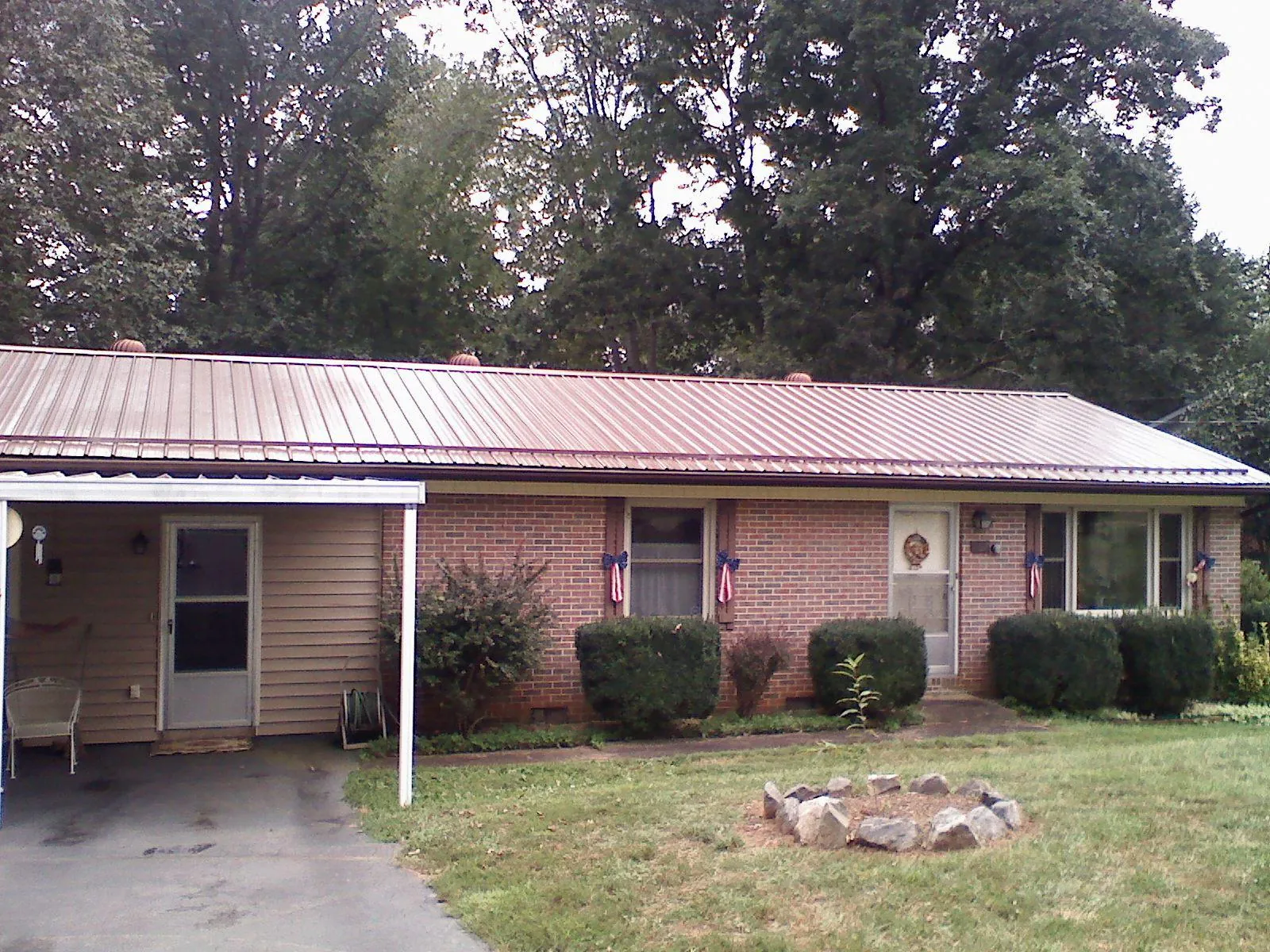 Bronze metal roof and carport on a brick ranch home — Roof Repair work by our crew in Good Thunder